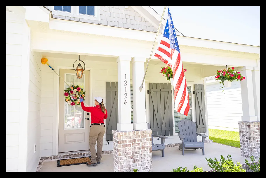 an employee cleaning the front of a house